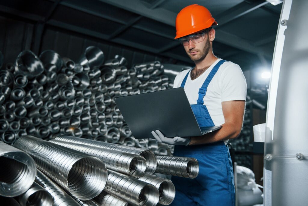 Conception of manufacturing. Man in uniform works on the production. Industrial modern technology